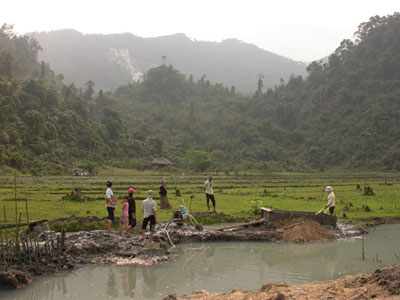 Spinel and ruby mining in rice fields near An Phu village, Luc Yen region, Vietnam. In the background are white marble cliff where spinels are also mined. Luc Yen Vietnam. Photo: V. Pardieu, 2005.