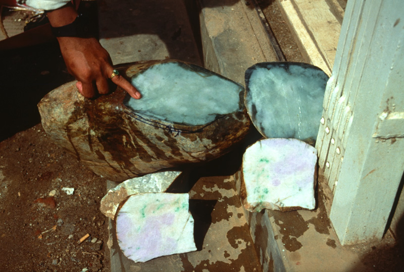 Sectioned jade boulder at Hpakan. The thick brown skin typically hides all traces of color inside. Only cutting reveals the true value. The pictured stone contains jade of both green and lavender colors