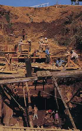 Figure 5. In some areas at Tawmaw, miners must dig deep shafts through the overburden to reach the jadeite dikes. Dirt and gravel are removed by a rudimentary winch-and-bucket system. Photo © 2000 Fred Ward.