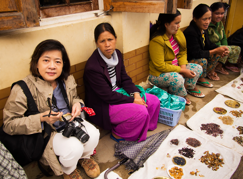 Figure 5. Wimon Manorotkul (left) joins dealers displaying rough gems in Mogok’s market. Over fifty different types of gems are found in the Stone Tract. Photo: E. Billie Hughes