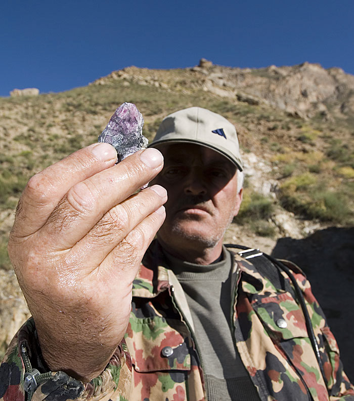 A miner at Kuh-i-Lal holds up a piece of impure spinel. Photo: Richard W. Hughes