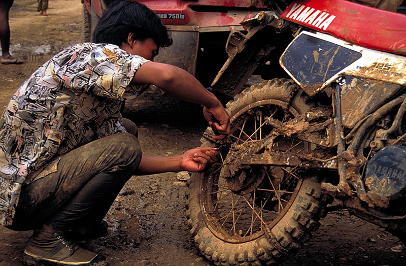 At Nyaungbin, a motorcyclist is seen removing chains. He told the authors it took him ten hours to ride from Hpakan, and he only fell five times.