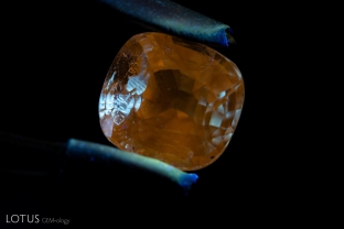 When illuminated with a longwave UV torch, the filler in a fissure in this sapphire displays a chalky appearance.