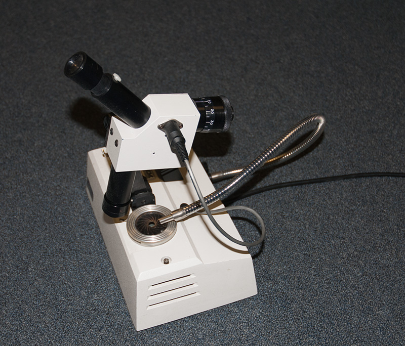 A scanning spectroscope once produced by Gem Instruments. Rotating the calibrated drum on the right of the instrument while viewing the spectrum through the eyepiece rolls the spectrum past a crosshair. When the absorption line is lined up with the crosshair, the exact wavelength can be read off of a digital LED display on the top of the instrument. The instrument is excellent for measuring the exact wavelengths of fine absorption and emission lines. Photo: R.W. Hughes