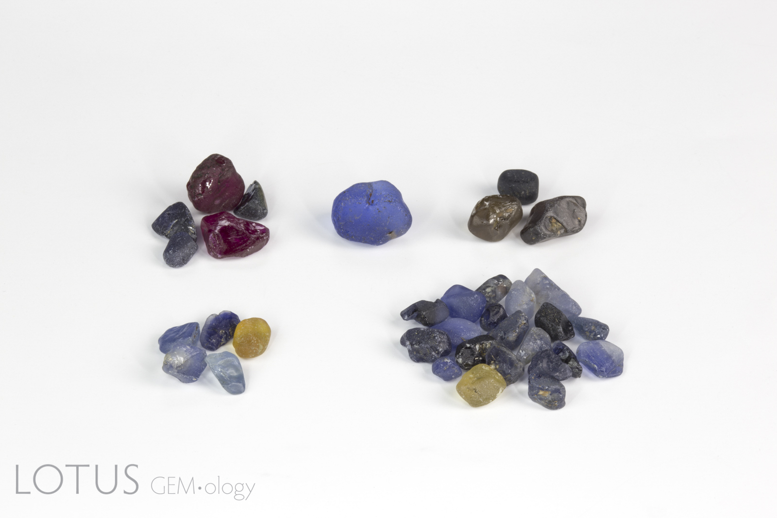 Rough gem samples purchased at Colorline’s Ilakaka office (clockwise from top left): Verneuil synthetic corundum, blue glass, zircon and spinel, coated natural sapphire; natural untreated blue and yellow sapphire. Note that these were purchased just to get a snapshot of what was in the market, even though we knew many were not what they were represented as. Photo: Wimon Manorotkul. 