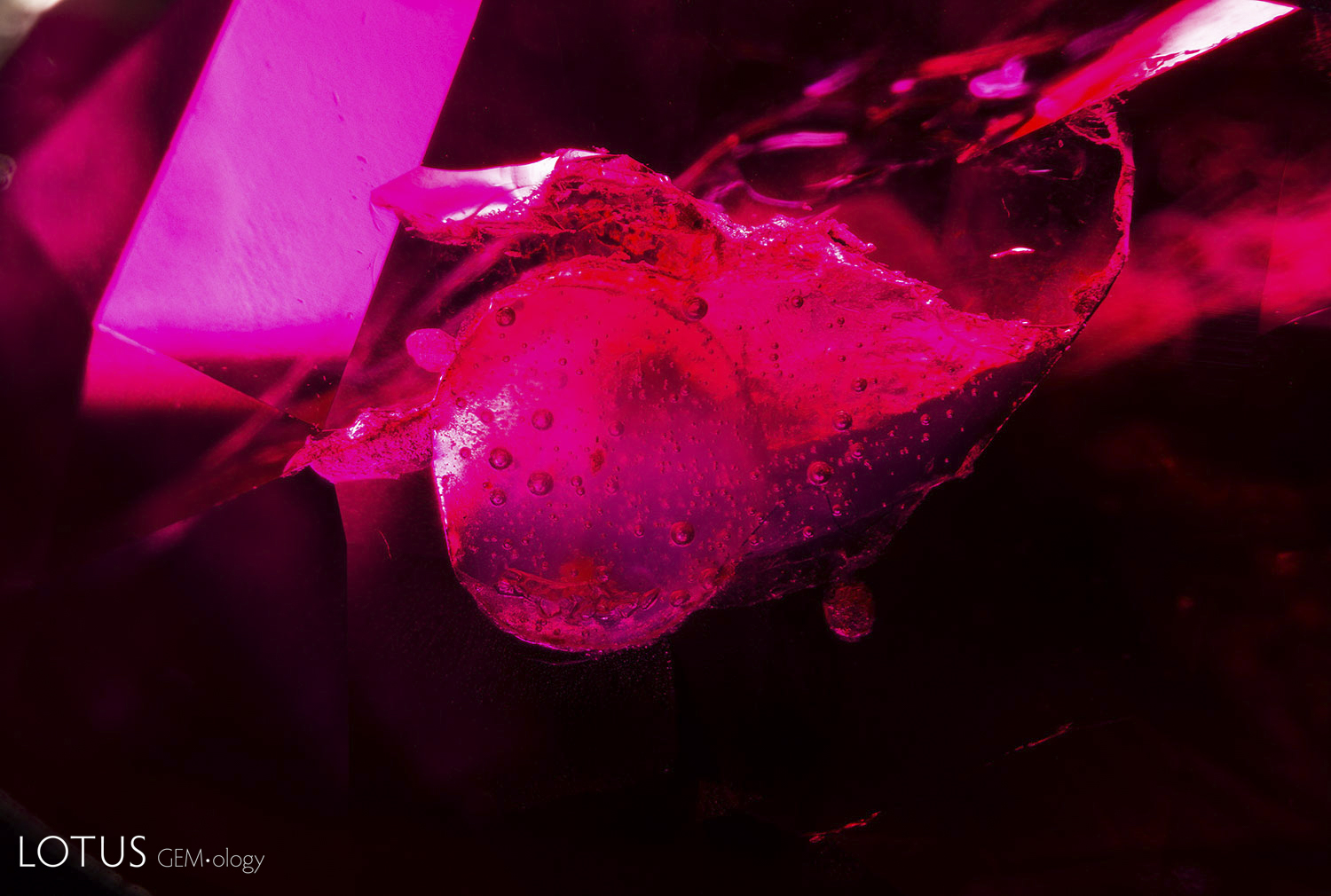 This ruby contains a surface reaching cavity that appears to contain hardened resin, depicted here with dark field illumination.