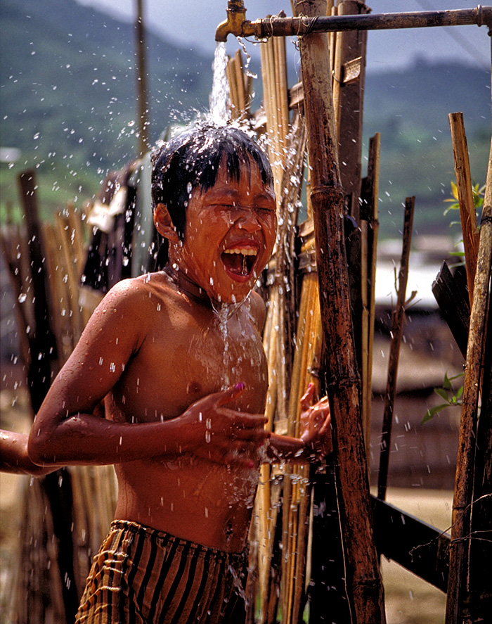 A young boy frolicking in the water near Mogok's Ho Mine, famous for producing some of the world's finest rubies. Water in Burma's Mogok Stone Tract brings smiles to all. Not only does the area's heavy rain (over 150 inches yearly) play a vital role in freeing rubies and other gems from their mountain birthplaces, but water is also a necessary element of the area's mining industry. Photo: R.W. Hughes