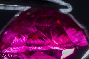 After this ruby grew, it was exposed to high pressure, causing certain planes of atoms to glide into a twinned position. This secondary “polysynthetic” twinning takes place along the rhombohedron faces and is common in many corundums. Twin planes cross at 86.1 and 93.9° angles.
