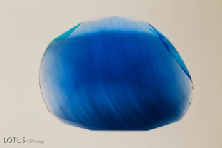 Curved growth lines are visible in this Verneuil synthetic sapphire when immersed in methylene iodide. These curved lines are a diagnostic feature of Verneuil synthetic corundum.