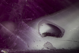 The surface of this glass-filled cavity shows a duller luster when compared to the higher luster of the corundum.