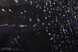 A “ghost” fissure in a Sri Lankan sapphire treated with high-temperature heating plus pressure (HT+P). In crossed polars, the fissure shows transparent doubly refractive crystals. These have previously been identified as corundum by Lotus gemologists using microRaman. These tiny synthetic corundum crystals form during the treatment. Nathan Renfro of the GIA was the first to notice these ghost crystals. E. Billie Hughes of Lotus Gemology was the first to identify them. FoV=4 mm.