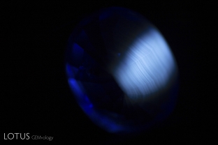 Using magnification with shortwave ultraviolet light, one can see the chalky fluorescence in curved bands, revealing the synthetic nature of the gem.