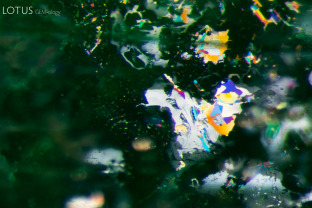 Iridescent thin films form a dramatic topographical scene in this emerald.