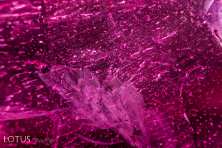 Douros synthetic flux ruby overgrowth on a natural seed. The overgrowth is quite thin and the interface shows tiny spots in lines.